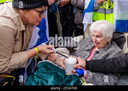 March for Life, London, UK. 6th May 2024. 94 year old Holocaust Survivor, Renee Salt, is helped lighting a memorial candle at a Reconciliation Ceremony at Richmond Terrace, Westminster following the historic and first-ever March of Life, London, organised by the Christian Action Against Antisemitism (CAAA), to commemorate Yom HaShoah Holocaust Remembrance Day. Photo by Amanda Rose/Alamy Live News Stock Photo