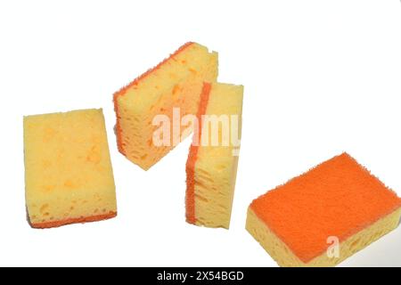 Orange kitchen sponges lie chaotically on a white background. Stock Photo