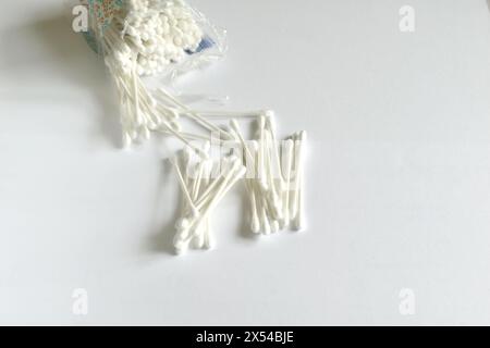 White cotton swabs for cleaning ears lie on a white background. Stock Photo