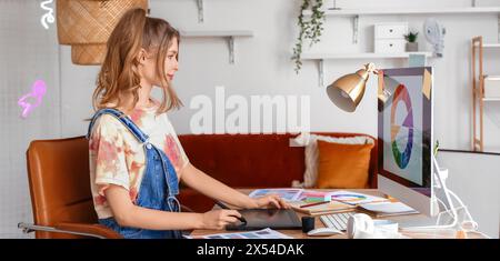 Female graphic designer working with tablet at table in office Stock Photo