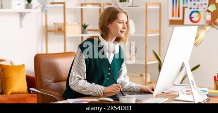 Female graphic designer working with tablet at table in office Stock Photo