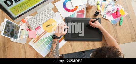 Male graphic designer working with tablet in office, top view Stock Photo