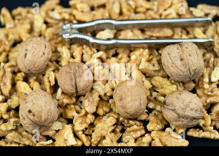 walnut (Juglans regia), Walnuts, whole and cracked, with nutcracker Stock Photo