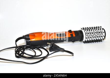 Electric hair dryer brush for creating volume in a woman's hairstyle on the head. Stock Photo
