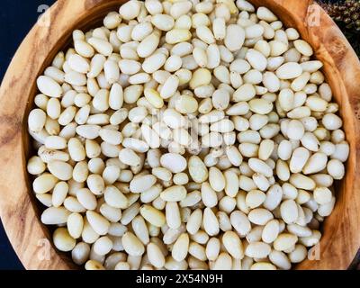 Stone pine, Italian Stone pine, Umbrella Pine (Pinus pinea), Pine nuts in a wooden bowl Stock Photo