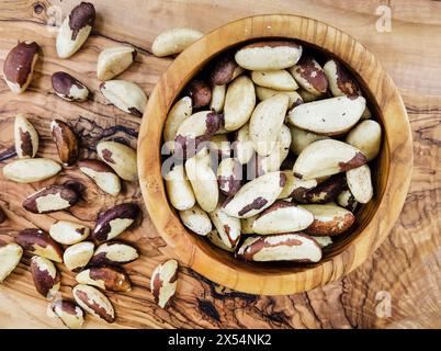 Brazil nut, butter nut, cream nut, para nut (Bertholletia excelsa), cracked Brazil nuts in a wooden bowl Stock Photo