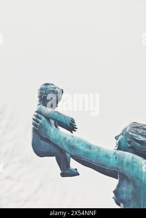 Bronze sculpture mother holding child in outstretched arms by Norwegian sculptor Gustav Vigeland, The Bridge Frogner Park, Vigeland Park, Oslo, Norway Stock Photo