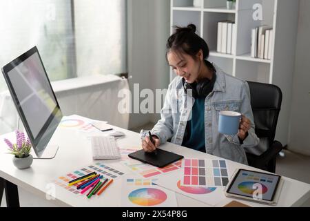UX designer. Work on creative applications. Man with a palette in his hands. Designer applies the primary colors to the monitors. Development of a Stock Photo