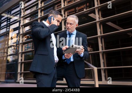 Two businessmen with digital tablet looking at the results of the project. Stock Photo