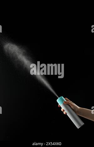 Spraying aerosol on black background Stock Photo - Alamy