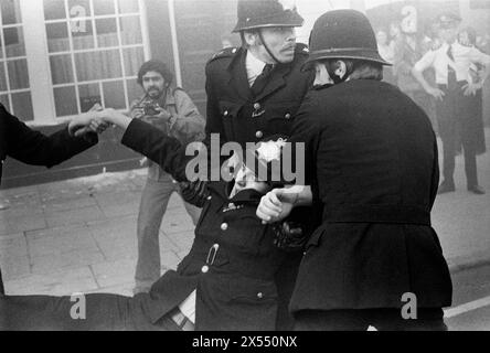 Police officer wounded in violent riots London UK 1970s. Battle of Lewisham, which took place on 13 August 1977. 500 members of the National Front marched from New Cross to Lewisham, various counter-demonstrations by approximately 4,000 people led to violent clashes between the two groups and between the anti-NF demonstrators and police. 5,000 police officers were present and 56 officers were injured in the riots, 11 of whom were hospitalised. South London, England. HOMER SYKES Stock Photo