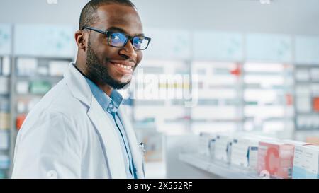 Pharmacy: Portrait of Professional Black Pharmacist Uses Digital Tablet Computer, Checks Inventory of Medicine, Looks at Camera and Smiles Charmingly. Drugstore Store with Health Care Products Stock Photo