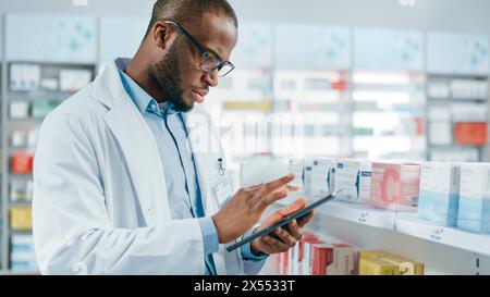 Pharmacy: Portrait of Professional Black Pharmacist Uses Digital Tablet Computer, Checks Inventory of Medicine, Drugs, Vitamins on a Shelf. Druggist in Drugstore Store Arranging Health Care Products Stock Photo