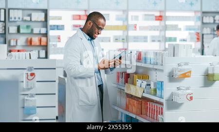 Pharmacy: Portrait of Professional Black Pharmacist Uses Digital Tablet Computer, Checks Inventory of Medicine, Drugs, Vitamins, Health Care Products. Druggist in Drugstore Store. Stock Photo