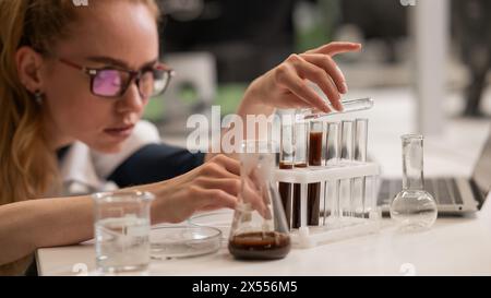 Caucasian woman in a medical gown doing laboratory experiments.  Stock Photo