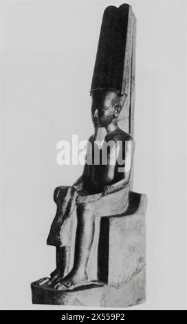 Granite Sculpture of the God Amun Protecting King Tutankhamun,' dated around 1200 B.C., XVIIIth Dynasty, housed at the Louvre Museum, Paris, France. This seated sculpture captures Amun, the king of gods, protecting King Tutankhamun. This piece has signs of mutilation, believed to be the work of his successor, Horemheb, who aimed to erase Tutankhamun's legacy and disrupt his divine protection. Stock Photo