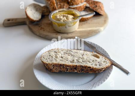 Piece of bread with hummus on a white plate Stock Photo