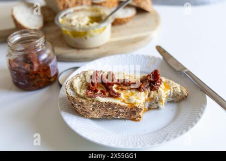 Piece of bread with hummus on a white plate Stock Photo