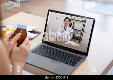 Elderly woman sit at home having online consultation with doctor on computer laptop, sick senior talk on video call consulting with nurse using laptop Stock Photo