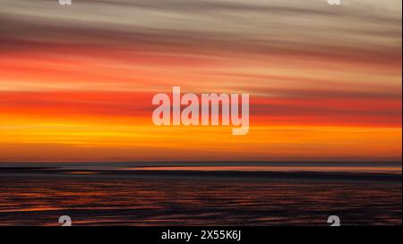 Bright orange and yellow sunset over Morecambe bay Stock Photo