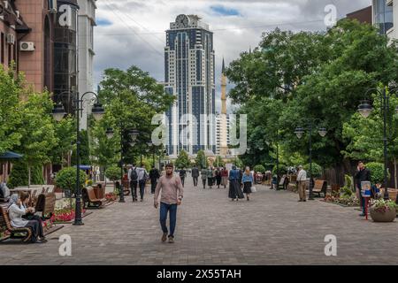 The people walk down the downtown of Grozny, the capital or Chechnya Republic, while Grozny City skyscrapers and the mosque are seen in background. Stock Photo