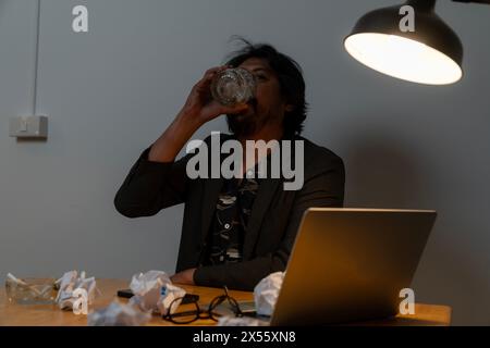 The businessman has failed in his work and is drinking alcohol Stock Photo
