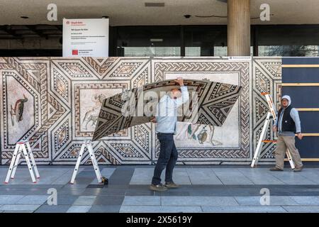 a reproduction with excerpts from the Dionysus mosaic is mounted on the construction fence of the Roemisch-Germanisches Museum on Roncalliplatz, Colog Stock Photo