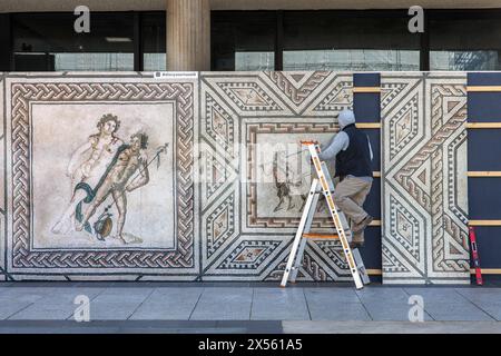 a reproduction with excerpts from the Dionysus mosaic is mounted on the construction fence of the Roemisch-Germanisches Museum on Roncalliplatz, Colog Stock Photo