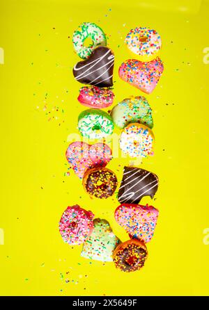 Multicolored donuts isolated on yellow background. Top view Stock Photo