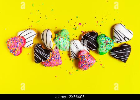 Multicolored donuts isolated on yellow background. Top view Stock Photo