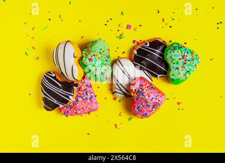 Multicolored donuts isolated on yellow background. Top view Stock Photo