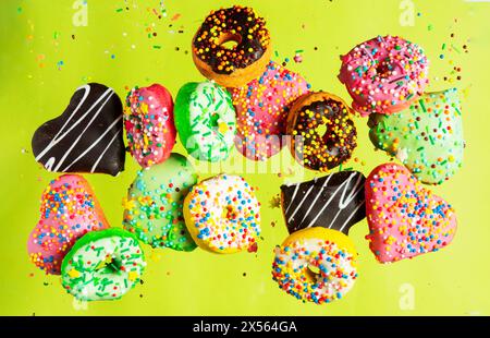 Multicolored donuts isolated on yellow background. Top view Stock Photo
