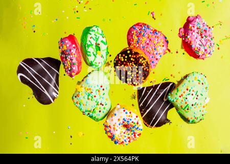 Multicolored donuts isolated on yellow background. Top view Stock Photo