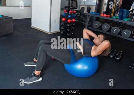 Sporty woman exercising on multistation at gym . Fitness exercising in gym Stock Photo
