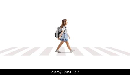 Full length profile shot of a little girl with a backpack crossing a street at a pedestrian zebra sign isolated on white background Stock Photo