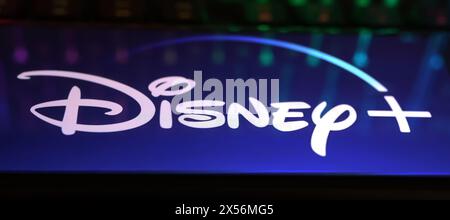 Viersen, Germany - May 1. 2024: Closeup of smartphone with logo lettering of Disney Plus streaming service channel  on computer keyboard Stock Photo