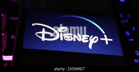 Viersen, Germany - May 1. 2024: Closeup of smartphone with logo lettering of Disney Plus streaming service channel  on computer keyboard Stock Photo