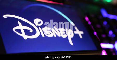 Viersen, Germany - May 1. 2024: Closeup of smartphone with logo lettering of Disney Plus streaming service channel  on computer keyboard Stock Photo