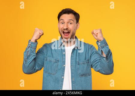 Man in Blue Shirt Holding Fists Up Stock Photo