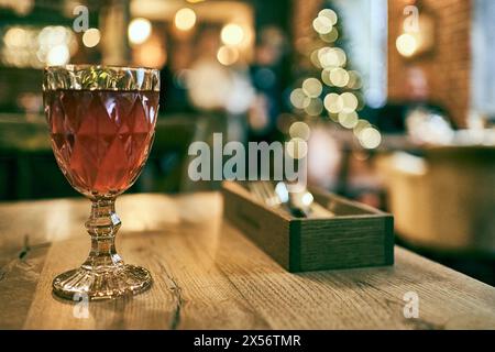 Fresh blackcurrant compote served in a multi-faceted glass on a wooden table with space for copying. High quality photo Stock Photo