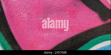 Messy black, green, white paint spray strokes and smudges on old pink painted wall. Abstract urban art background. Stock Photo