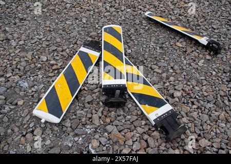 4 yellow and black caution signs lying on the gravel Stock Photo