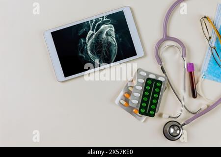 In hospital setting cardiology physician examines render of patient's heart using 3D x-ray radiology scan on digital tablet Stock Photo