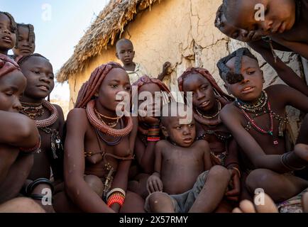 Group of Himba children and young woman look at pictures on a camera, near Opuwo, Kaokoveld, Kunene, Namibia Stock Photo