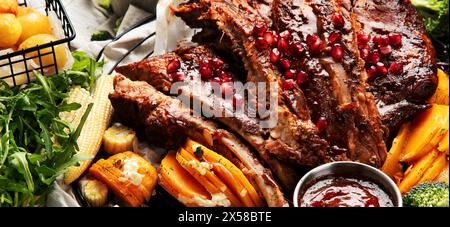 Pork ribs with vegetables on black background. Food for picnic concept. Stock Photo