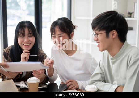 A group of cheerful Asian college students is enjoying studying math with a mature female professor in the classroom. education concept Stock Photo