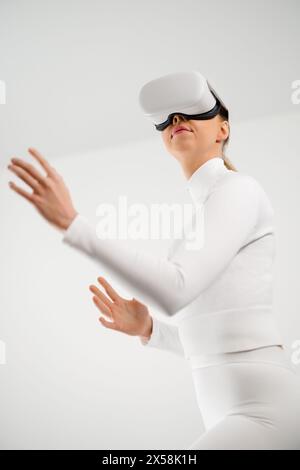 Young Woman Using Virtual Reality Headset in Minimal Setting Stock Photo