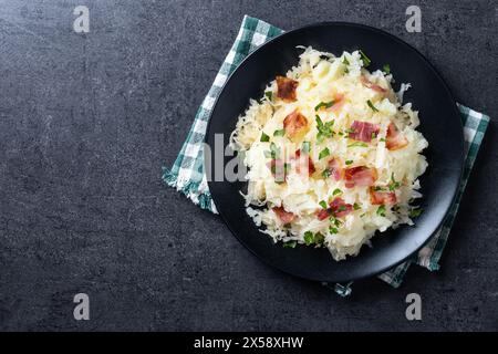 Slovak potato dumplings halusky with steamed sauerkraut and bacon on black background Stock Photo
