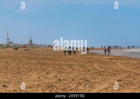 group of people strolling on a pleasant morning along the beaches of Cadiz. Stock Photo