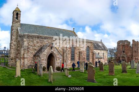 LINDISFARNE, HOLY ISLAND, NORTHUMBERLAND, UK - APRIL 25, 2024.  Landscape view of the Priory Church of St Mary next to Lindisfarne Priory on Holy Isla Stock Photo